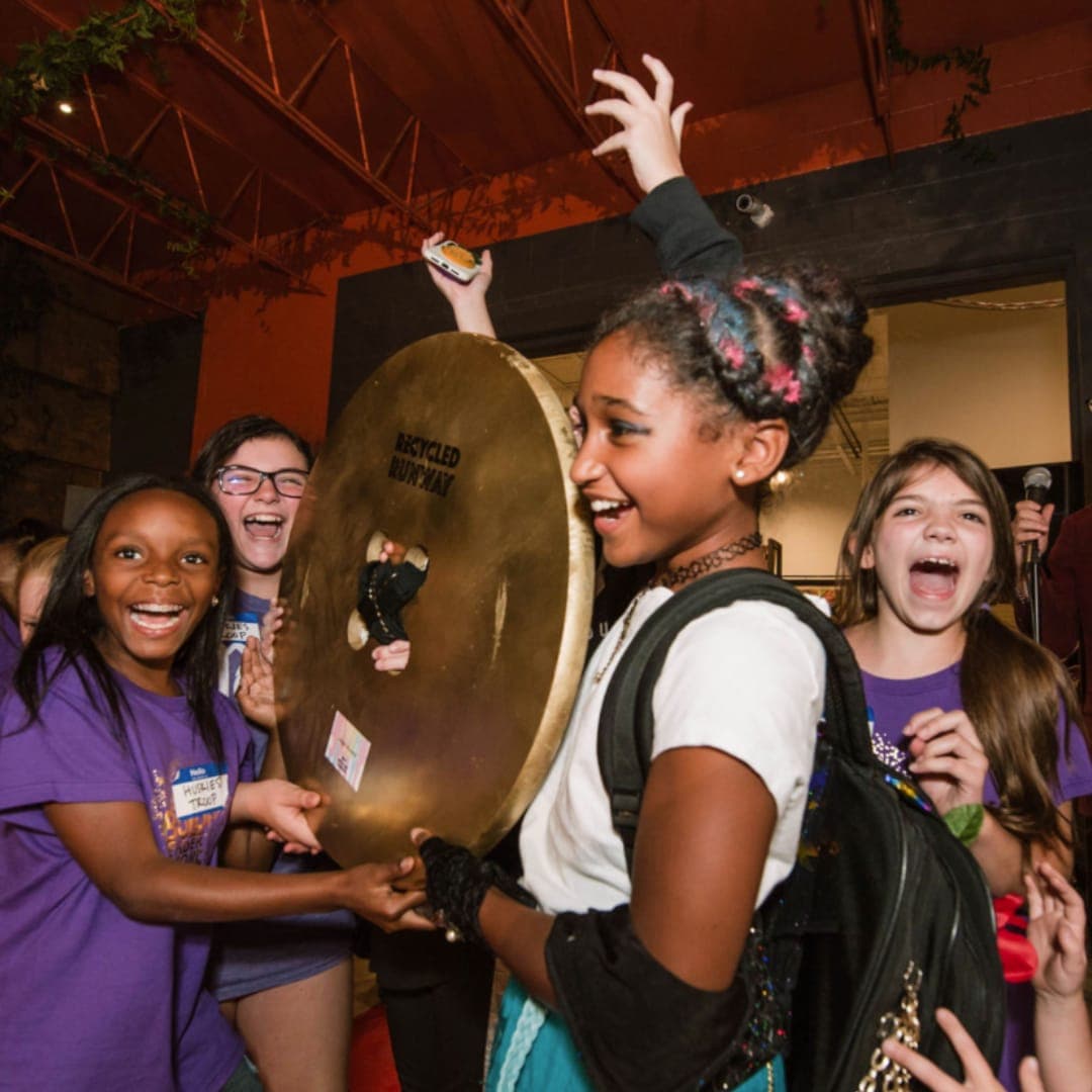 Kids shrieking with excitement around a giant gong