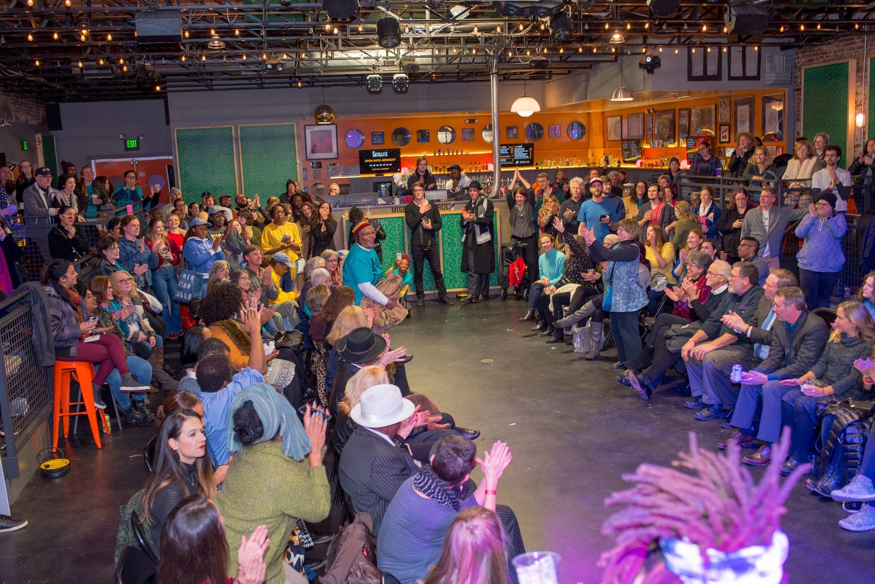 A packed warehouse audience around the runway