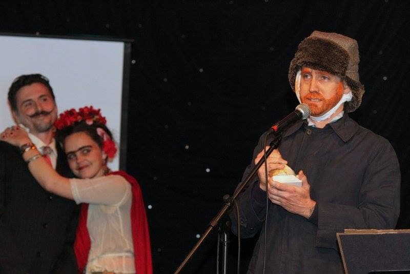 Artists in Van Gogh and Frida Kahlo costumes at the microphone