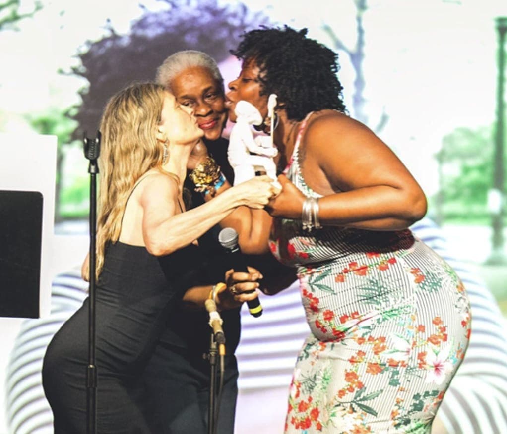Award winners hugging on stage