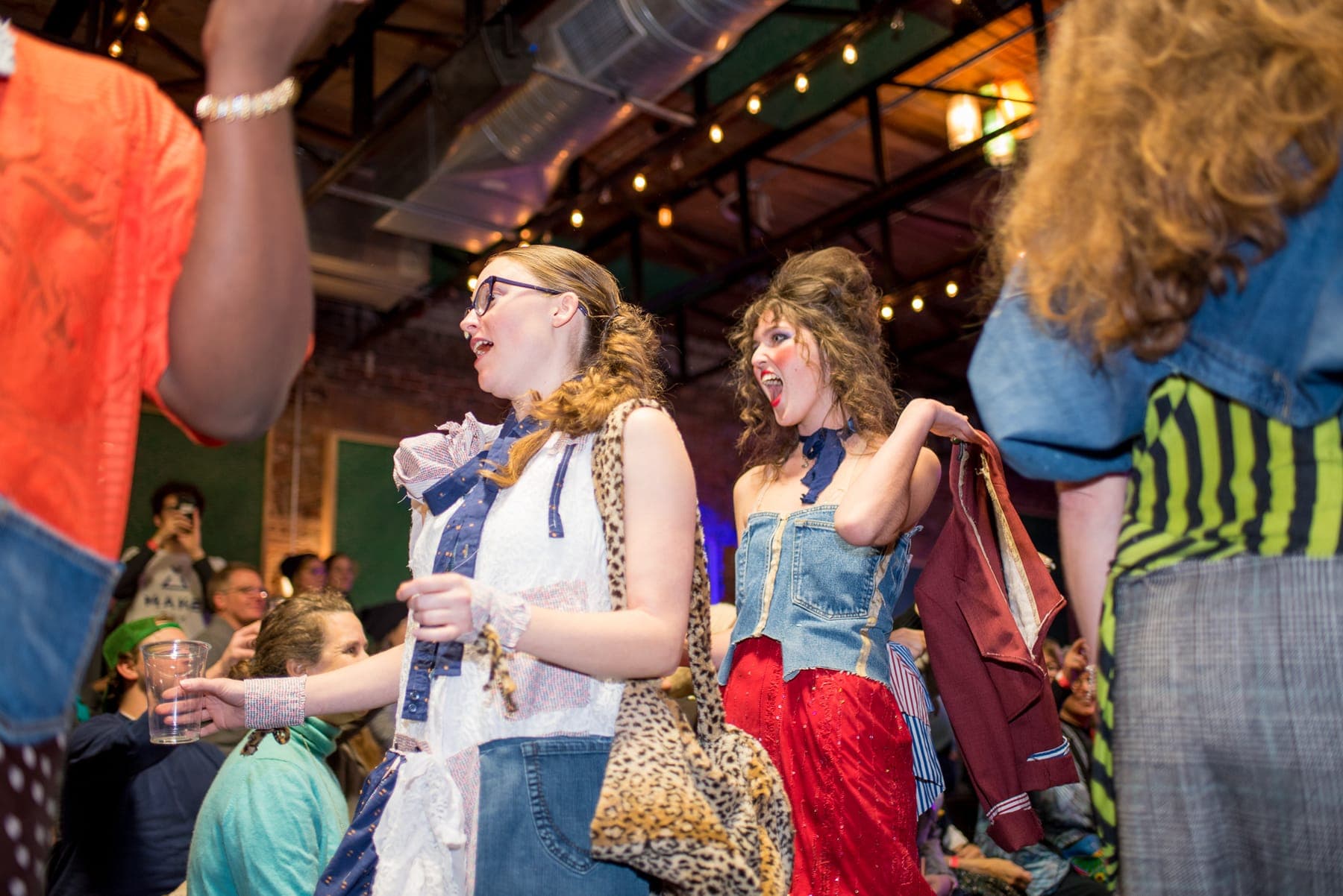 Contestants scrambling with garments during the sewing challenge