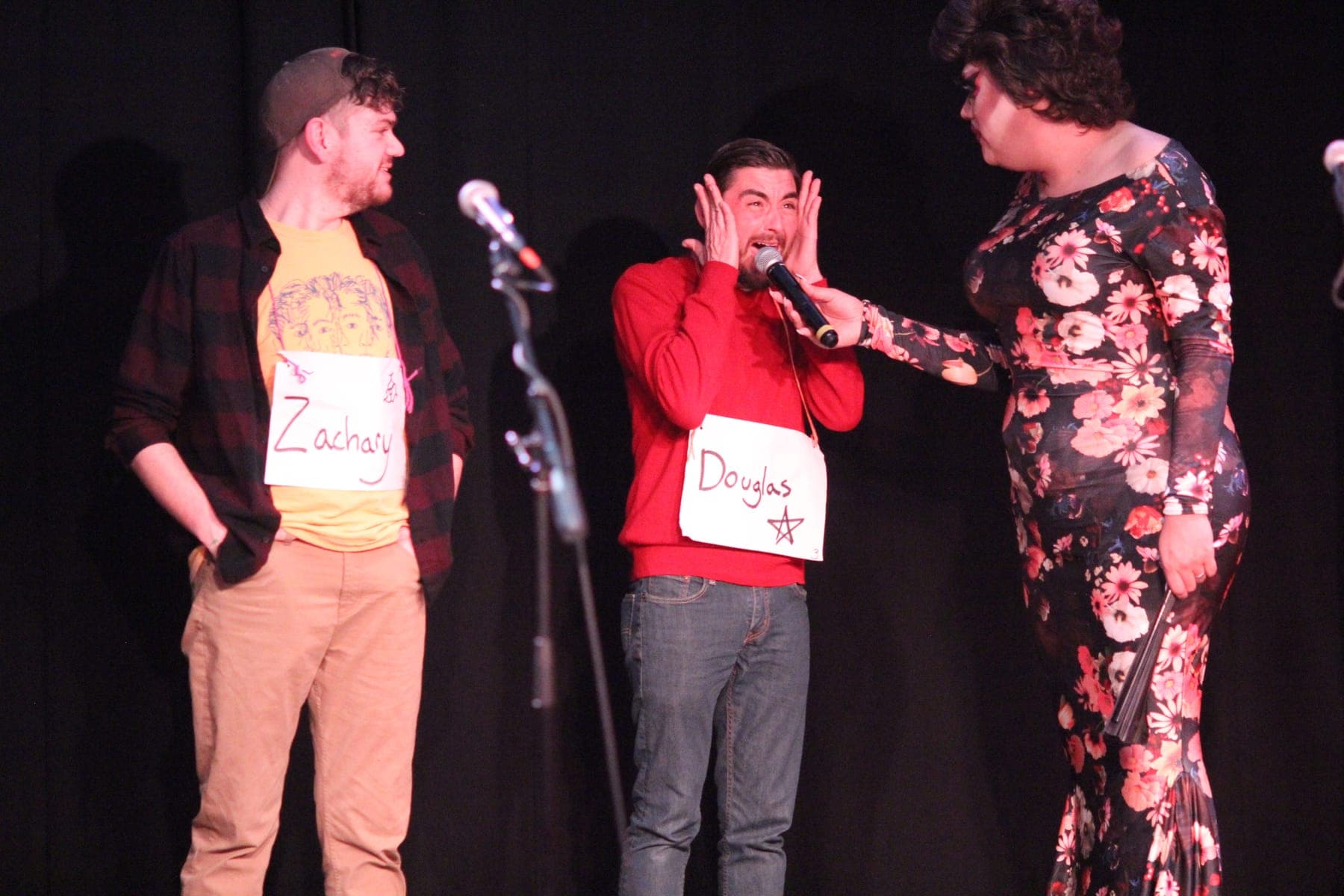A contestant reacting in mock horror as the co-host holds out the microphone